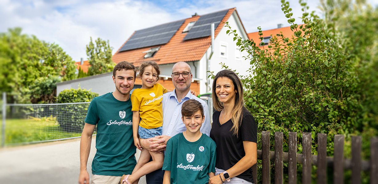 a family posing in front of a house with a pv-system